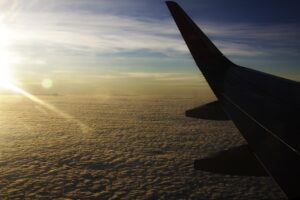 Immagine di un aereo in volo sopra nuvole, rappresenta la ricerca di voli economici.