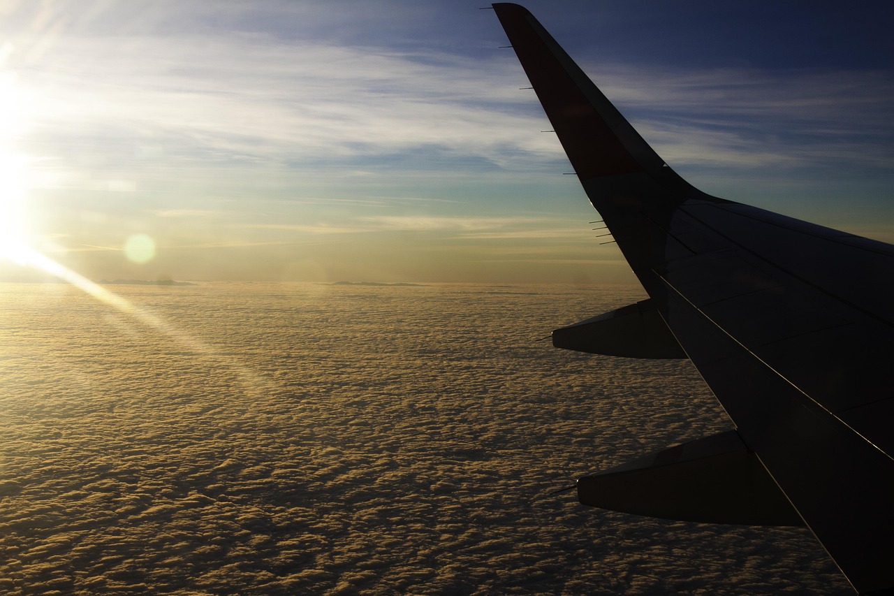 Immagine di un aereo in volo sopra nuvole, rappresenta la ricerca di voli economici.