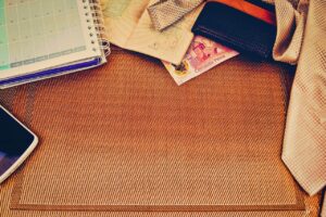 Due persone che pianificano un viaggio con mappe e computer, circondate da appunti e risorse di viaggio.